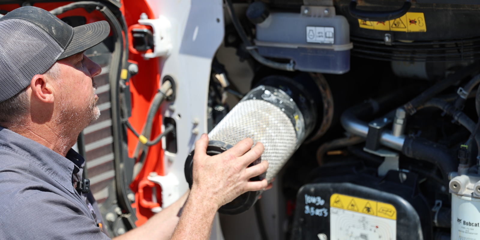 R-Series skid-steer and compact track loader engines sit in line with the machine, placing the engine air filters on the back of the machine. 